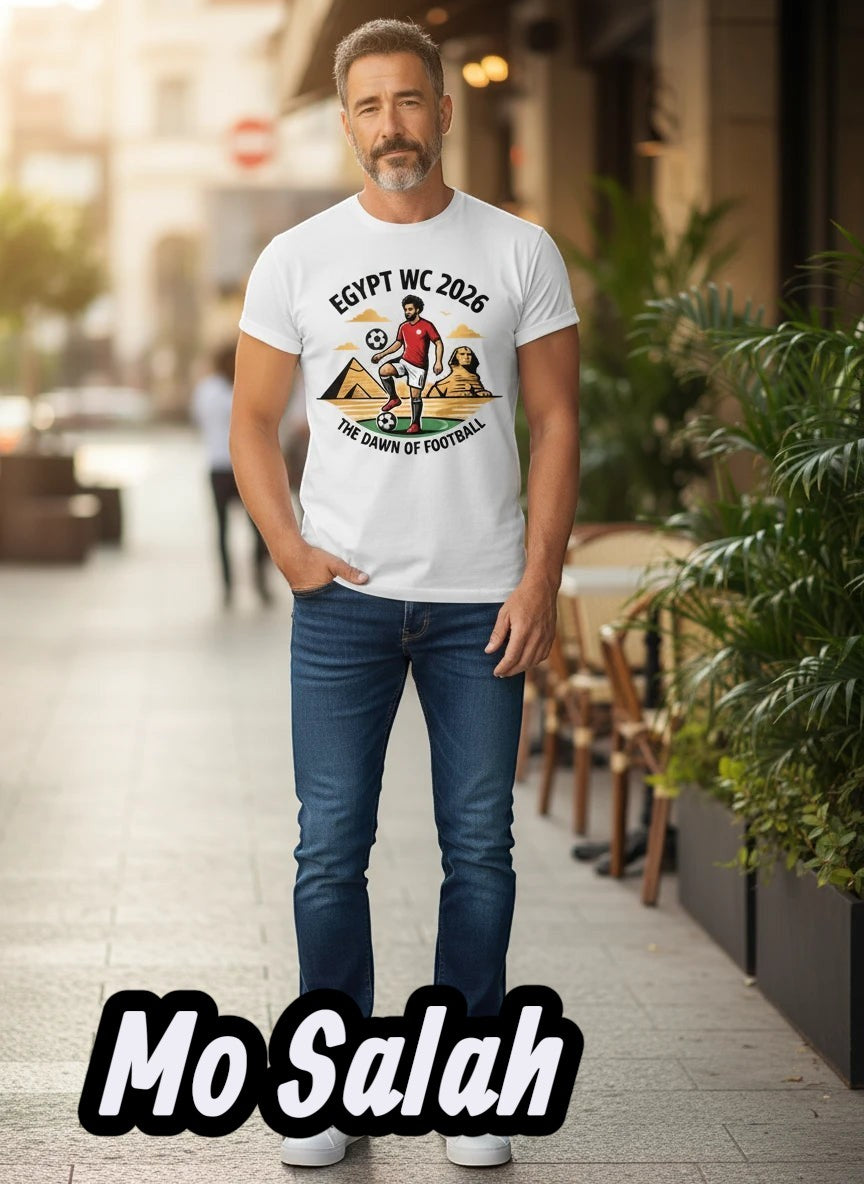 Coptic Mary Shop white cotton t-shirt with Egypt WC 2026 graphic featuring a footballer and pyramids.