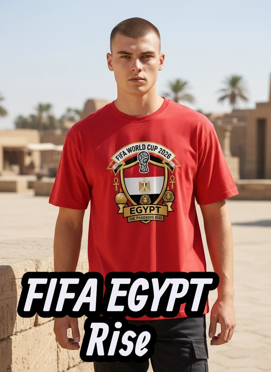 Coptic Mary Shop red cotton t-shirt with Egypt FIFA World Cup 2026 graphic crest and "The Pharaohs Rise" text.