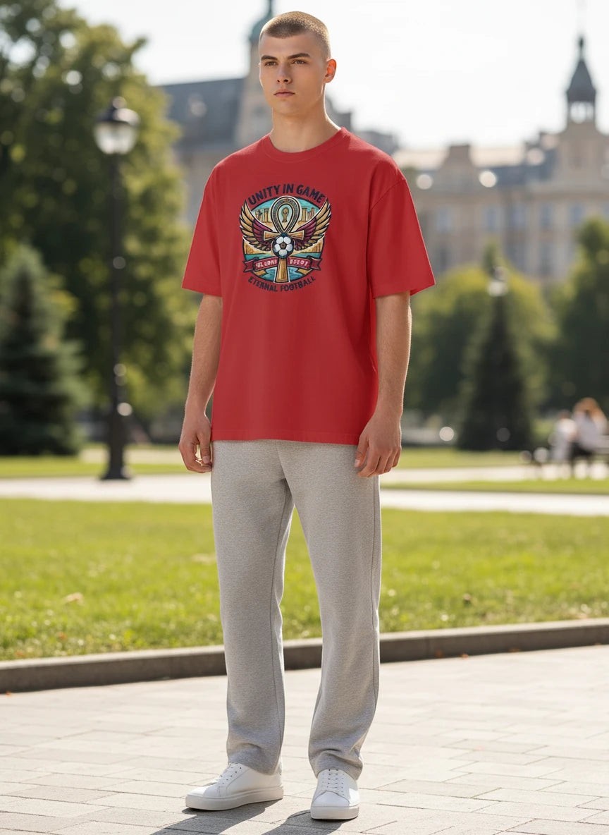 Coptic Mary Shop red cotton t-shirt with Egypt 2026 World Cup graphic featuring an ankh, wings, and football.